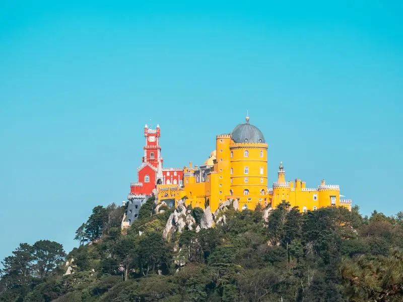 The red and yellow Pena Palace on its forested hilltop in Sintra, Portugal