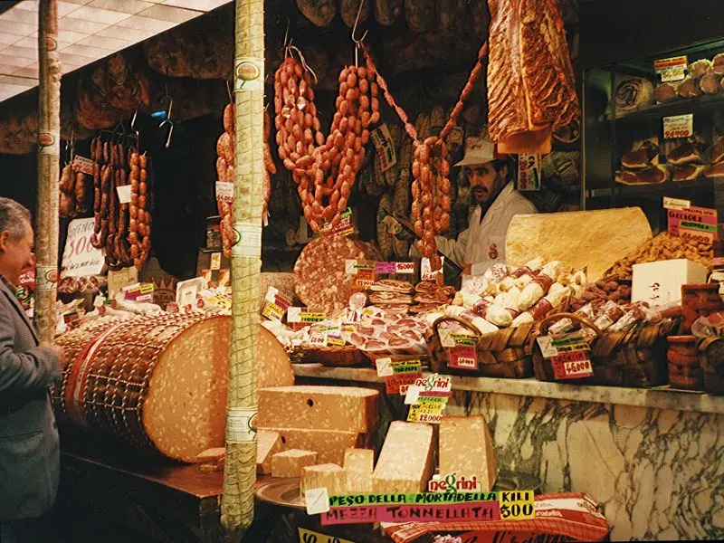 Italian deli counter in Florence stacked with cured meats, cheeses and fresh pasta