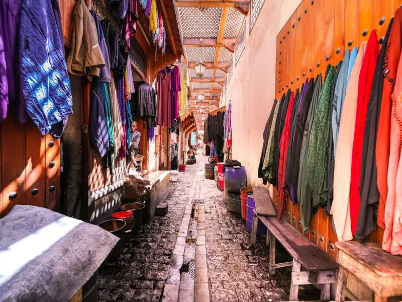 Colourful fabrics in a souk alley in the Marrakech medina